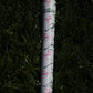 Golf club with a floral patterned grip on grass