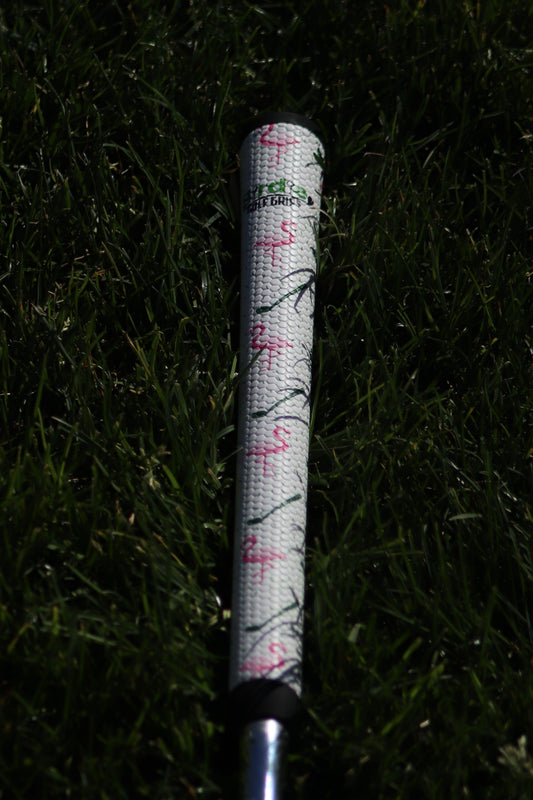 Golf club with a floral patterned grip on grass