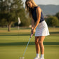 Woman putting on a golf course using a Birdie Golf Grips Freedom PG1 putter grip with American flag design.