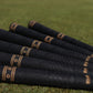 Birdie Golf Grips Smoke & Barrel black golf club grips with raised texture and gold detailing on a putting green.